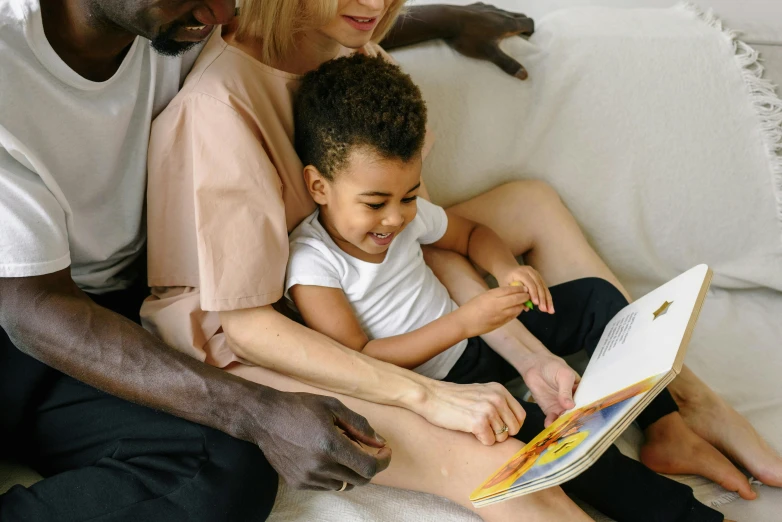 a family reading a book together on a couch, a child's drawing, pexels contest winner, black, cute boy, casually dressed, gif