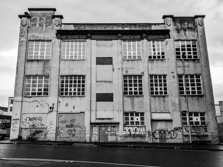 a black and white photo of an old building, a black and white photo, inspired by Thomas Struth, pexels contest winner, brutalism, industrial colours, boarded up, old school, detailed wide shot