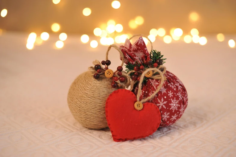 a couple of ornaments sitting on top of a bed, by Sylvia Wishart, pexels, burlap, red wires wrap around, mount, twas brillig