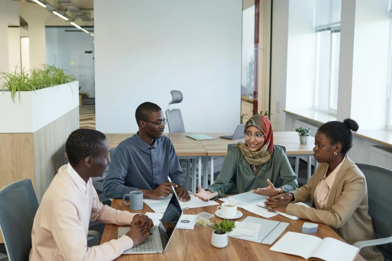 a group of people sitting around a wooden table, a picture, profile image, thumbnail, in office, african ameera al taweel