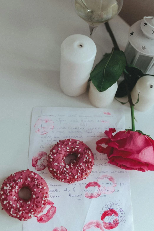 a couple of doughnuts sitting on top of a table, pexels contest winner, romanticism, roses, magical notes, low quality photo, milk