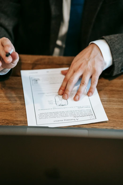 a man in a suit sitting at a table with papers, a cartoon, by Robbie Trevino, pexels contest winner, bump in form of hand, on a wooden tray, a person standing in front of a, highly details form