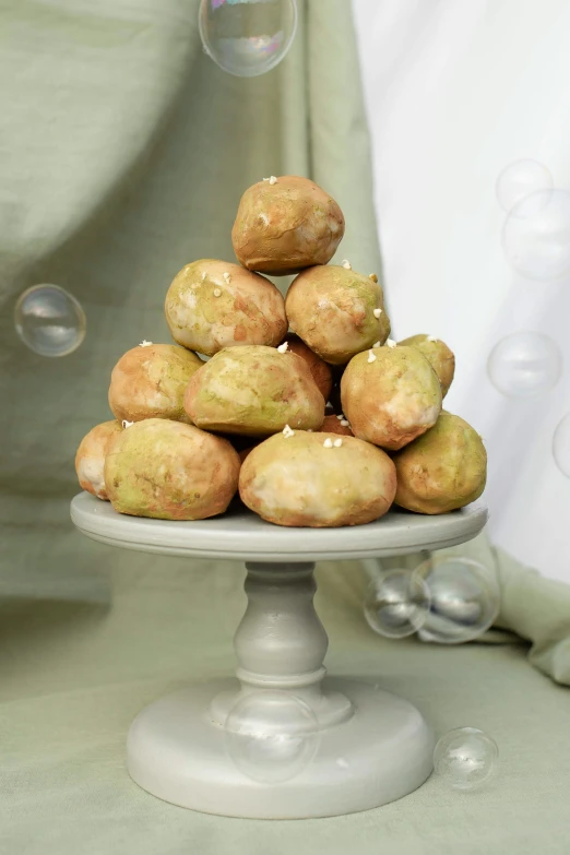 a pile of donuts sitting on top of a cake plate, baroque, glowing green rocks, puffballs, full product shot, petite pear slim figure