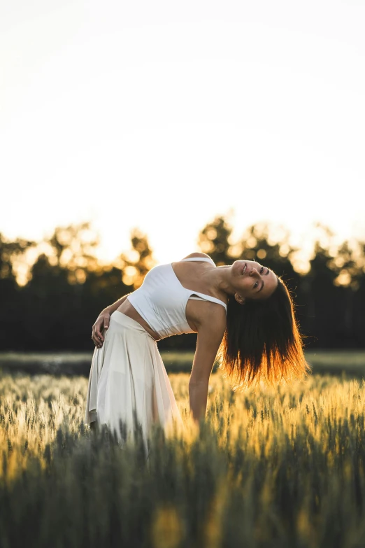 a woman standing in a field of tall grass, pexels contest winner, renaissance, yoga pose, warm glow, white, contorted