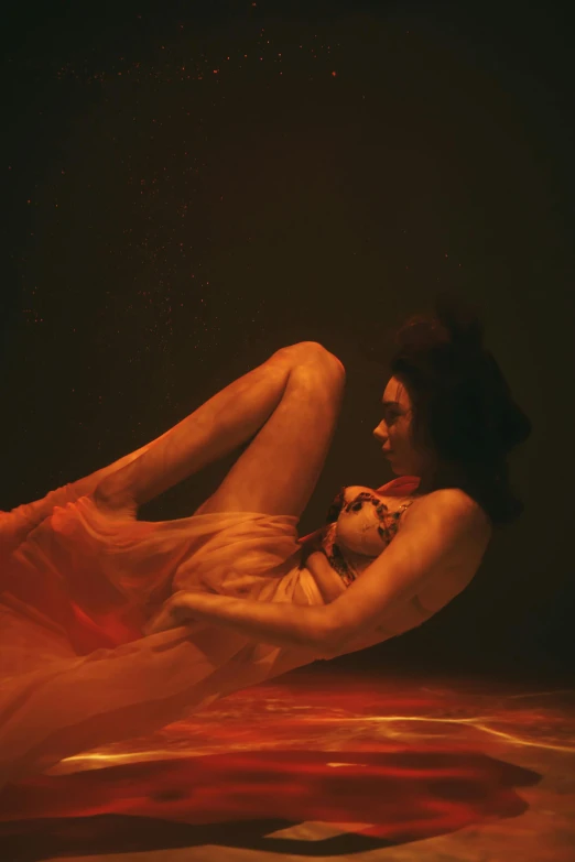 a woman laying on the floor in a dress, an album cover, inspired by Elsa Bleda, orange body, 4 k photo autochrome, covered in transparent cloth, showstudio