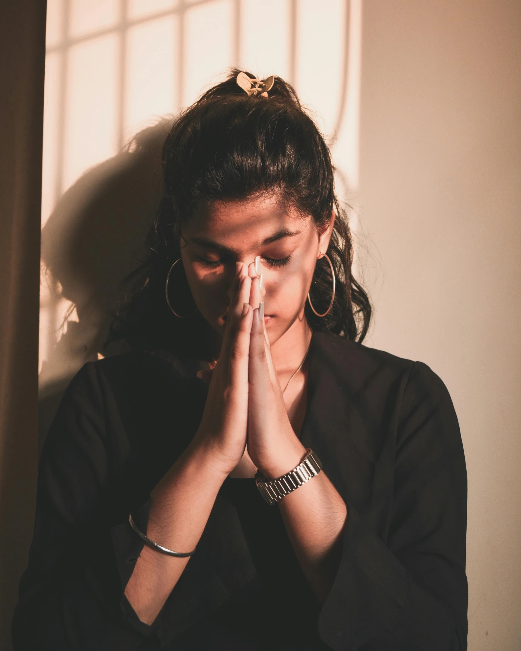 a woman is praying in front of a window, trending on unsplash, hurufiyya, lgbt, young himalayan woman, upset, on the altar