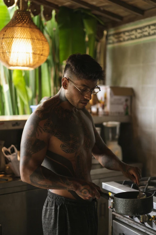 a man standing in a kitchen preparing food, a tattoo, by Jessie Alexandra Dick, pexels contest winner, djing with dj turntables, sweaty abs, bali, profile image