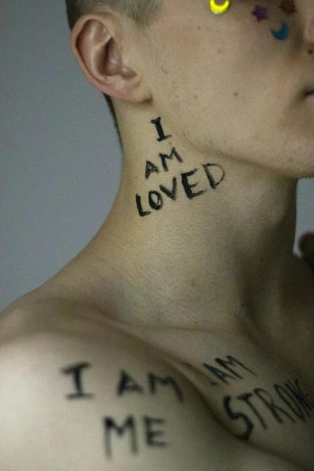 a man with the words i am loved written on his chest, by Silvia Pelissero, antipodeans, genderless, filmstill, teenage, lgbt