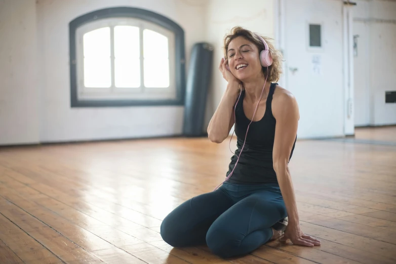 a woman sitting on the floor listening to music, by Nina Hamnett, trending on pexels, local gym, avatar image