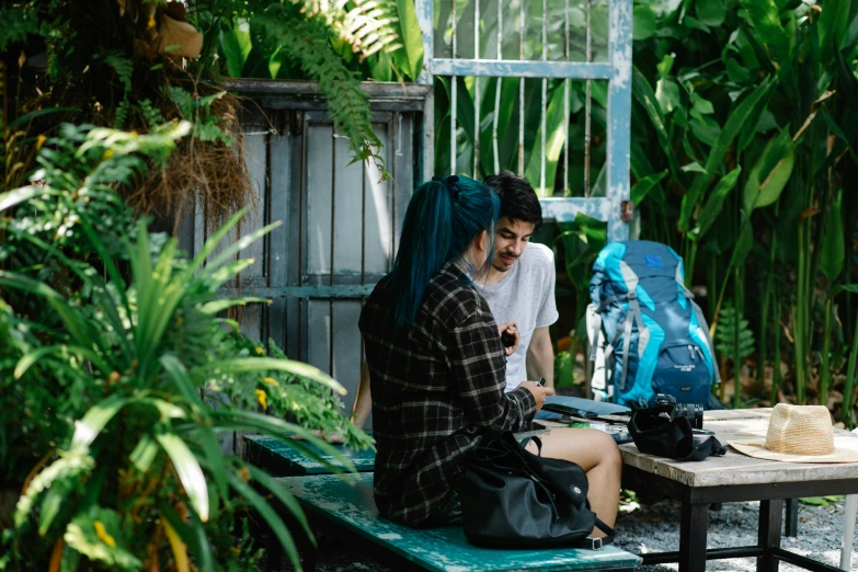 a couple of people that are sitting on a bench, inspired by Elsa Bleda, pexels contest winner, lush jungle, sitting on a table, green and black hair, traveller