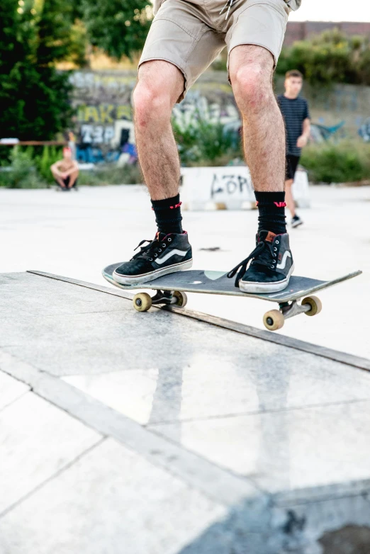 a man riding a skateboard up the side of a ramp, trending on unsplash, gray shorts and black socks, tournament, looking towards camera, veins popping out