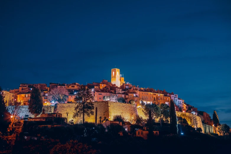 a castle lit up at night on top of a hill, by Julia Pishtar, pexels contest winner, renaissance, french village exterior, conde nast traveler photo, lourmarin, cannes