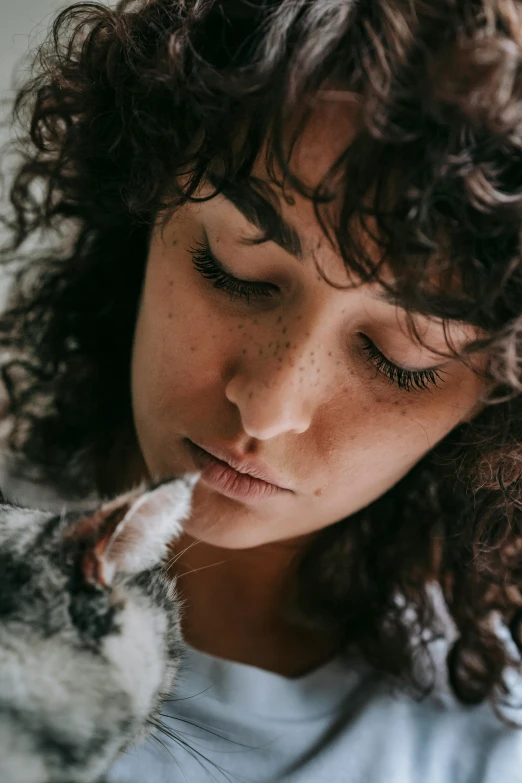 a close up of a person holding a cat, inspired by Elsa Bleda, trending on pexels, renaissance, curly bangs, portrait of a woman sleeping, speckled, teenager girl