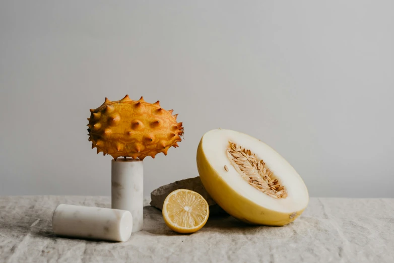 a close up of a fruit on a table, inspired by Sarah Lucas, unsplash, spiky, white marble sculpture, yellow aureole, high quality product photo