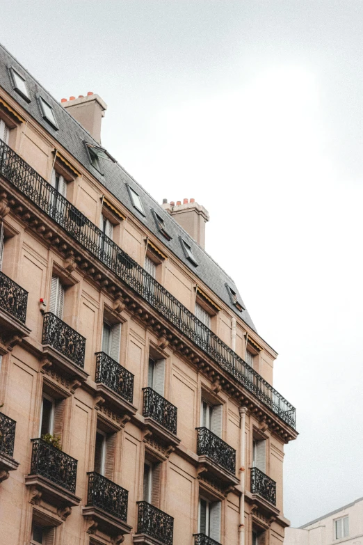 a tall building with balconies and balconies on the balconies, trending on unsplash, paris school, simple gable roofs, facing away from camera, rooftop romantic, high-resolution photo