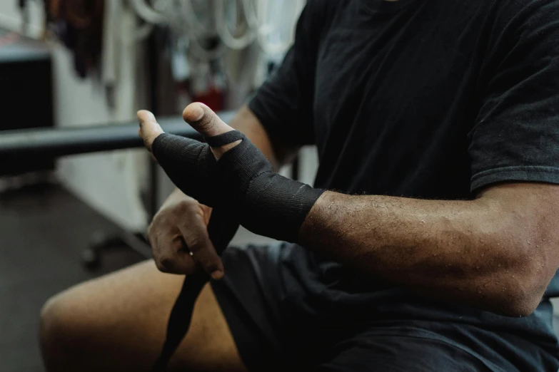 a man with a bandage sitting on a bench, pexels contest winner, local gym, bump in form of hand, black, sydney park