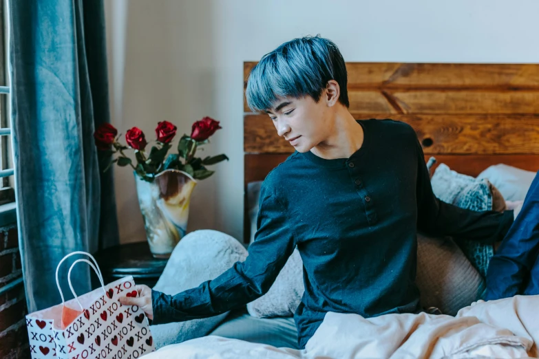 a man with blue hair sitting on a bed, by Julia Pishtar, pexels contest winner, giving gifts to people, jung jaehyun, thin young male, japanese collection product