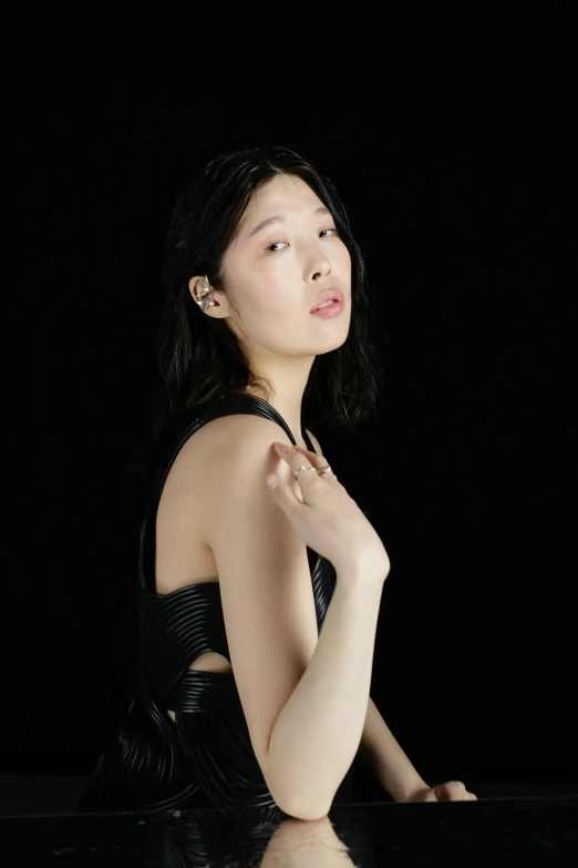 a woman sitting at a piano in front of a black background, an album cover, inspired by Jung Park, she is wearing a black tank top, bo chen, transparent background, ignant