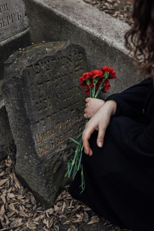 a woman sitting in front of a grave holding a bunch of flowers, by Attila Meszlenyi, unsplash, romanticism, 15081959 21121991 01012000 4k