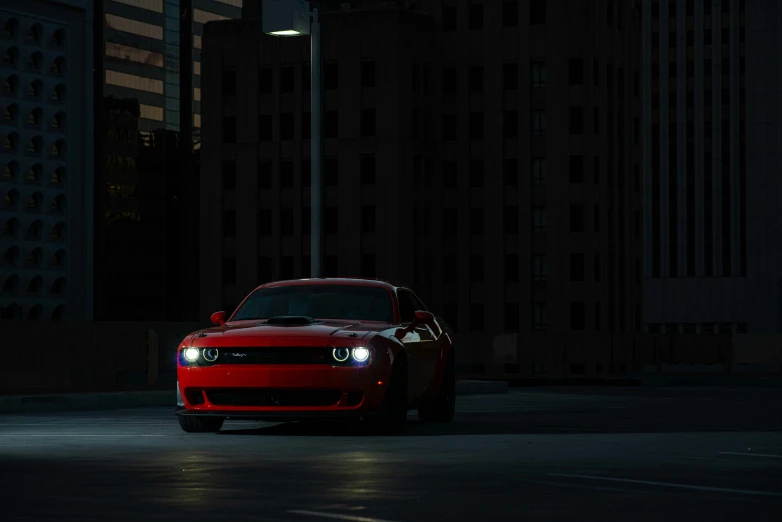 a red car driving down a city street at night, pexels contest winner, photorealism, muscle cars, volumetric lighting - n 9, lit in a dawn light, magicavoxel cinematic lighting