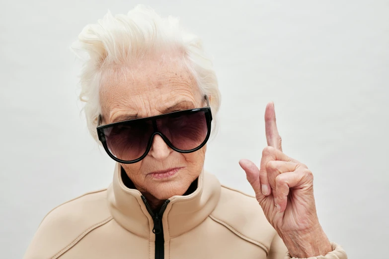 a close up of a person with a peace sign, inspired by Karl Buesgen, trending on unsplash, photorealism, old lady, doing a sassy pose, angry and pointing, aviator shades