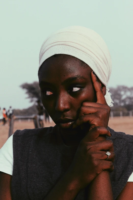 a woman in a turban talking on a cell phone, inspired by Ras Akyem, pexels contest winner, afrofuturism, girl with white eyes, ☁🌪🌙👩🏾, black teenage girl, unmistakably kenyan