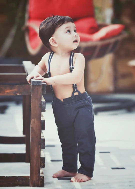 a little boy standing on top of a wooden bench, by Lucia Peka, trending on instagram, matte navy - blue bodysuit, suspenders, on rooftop, fullbody view