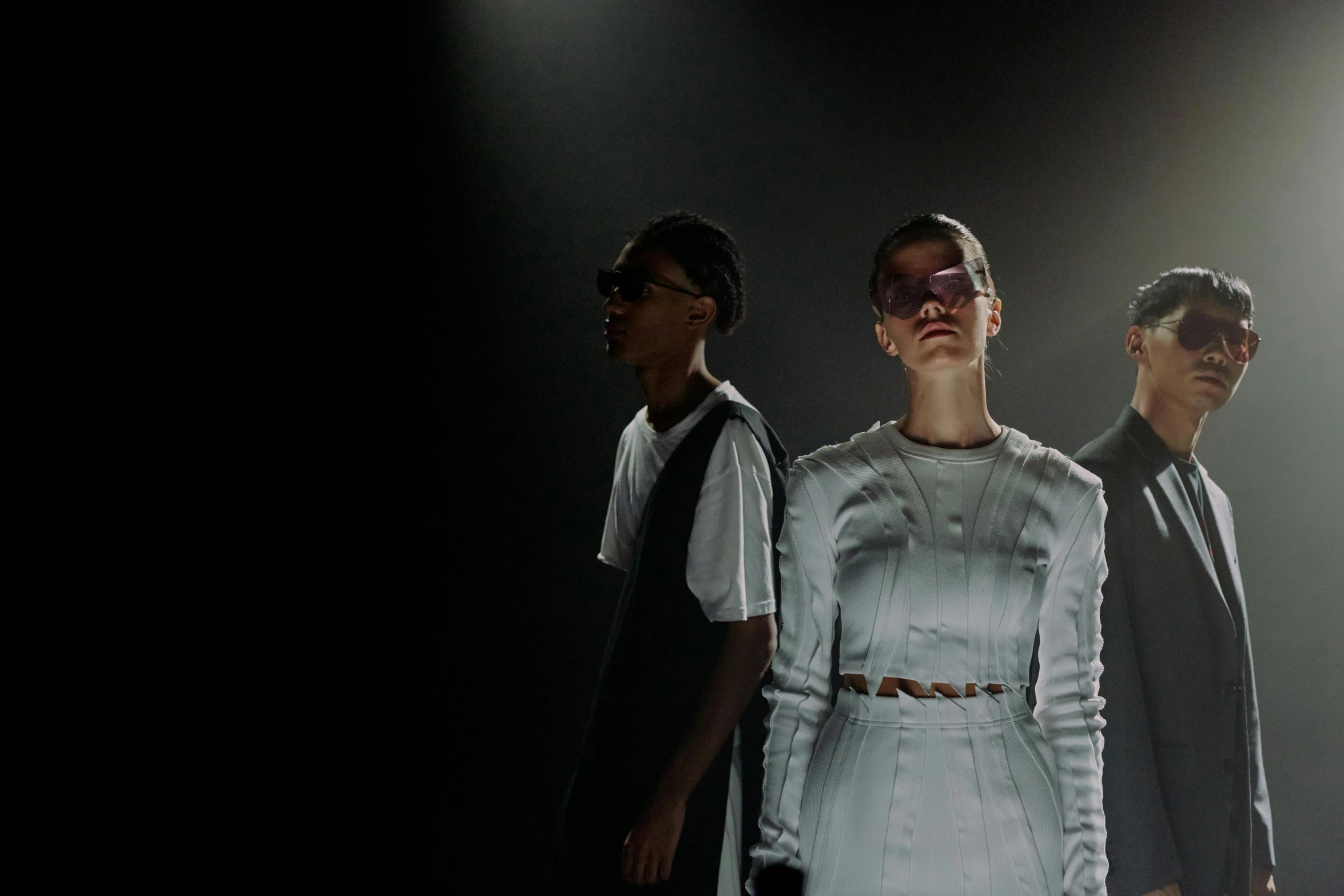 a group of people standing next to each other on a stage, a digital rendering, pexels, bauhaus, nico wearing a white dress, dramatic backlighting, portrait willow smith, dark shades