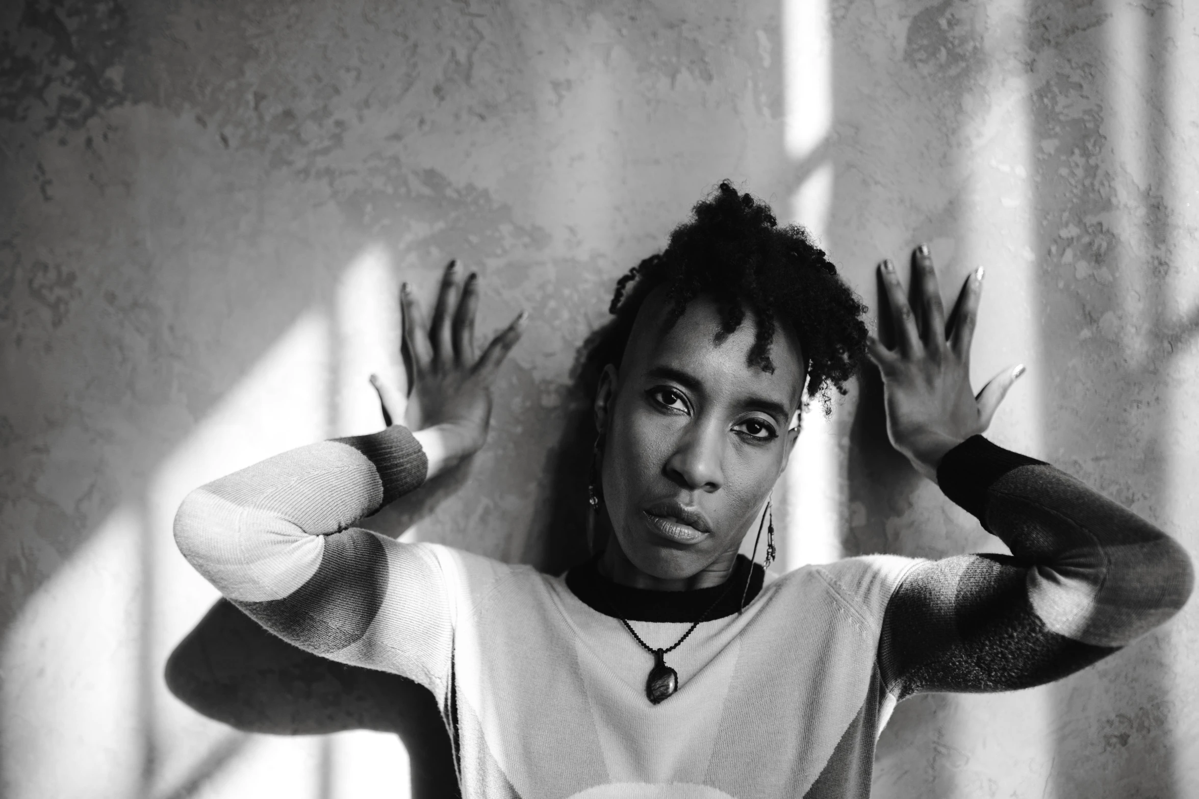 a black and white photo of a woman holding her hands up, inspired by Carrie Mae Weems, pexels contest winner, bauhaus, portrait androgynous girl, ashteroth, intense look, lil uzi vert