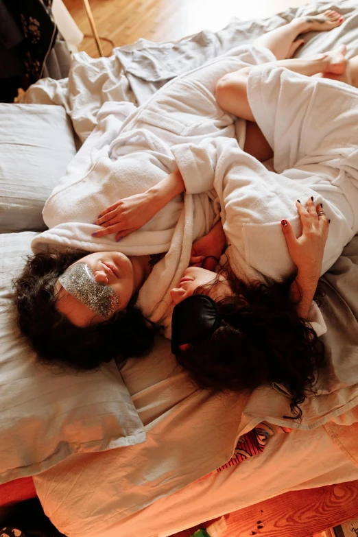 a couple of people laying on top of a bed, wearing a white robe, holding each other, slide show, alessio albi and shin jeongho