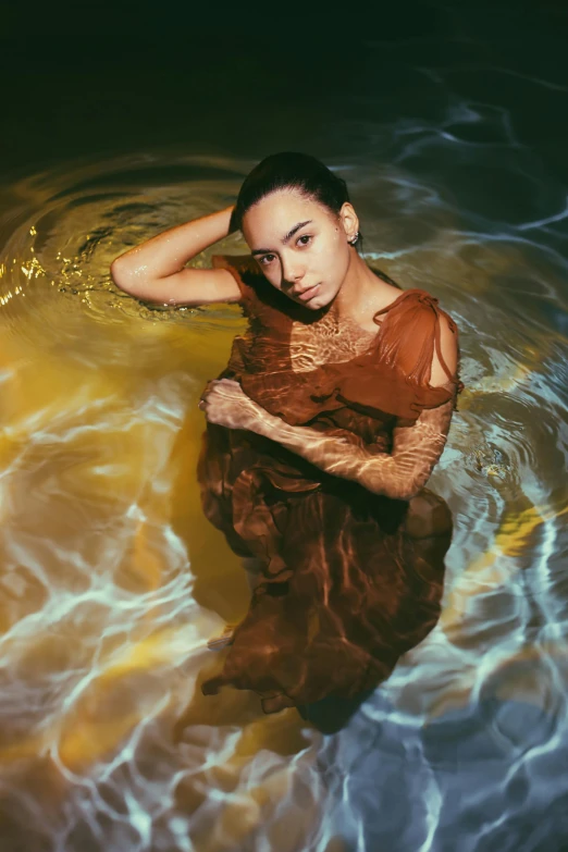 a woman floating in a body of water, an album cover, inspired by Elsa Bleda, pexels contest winner, renaissance, kiko mizuhara, brown clothes, liquid gold, :: madison beer