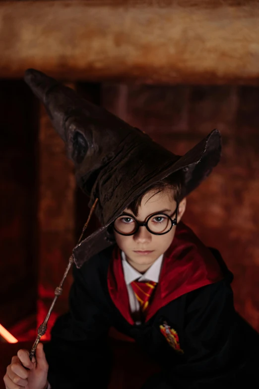 a young boy dressed in a harry potter costume holding a wand, a portrait, pexels contest winner, conceptual art, pointy conical hat, with glasses, cosplay photo, resin