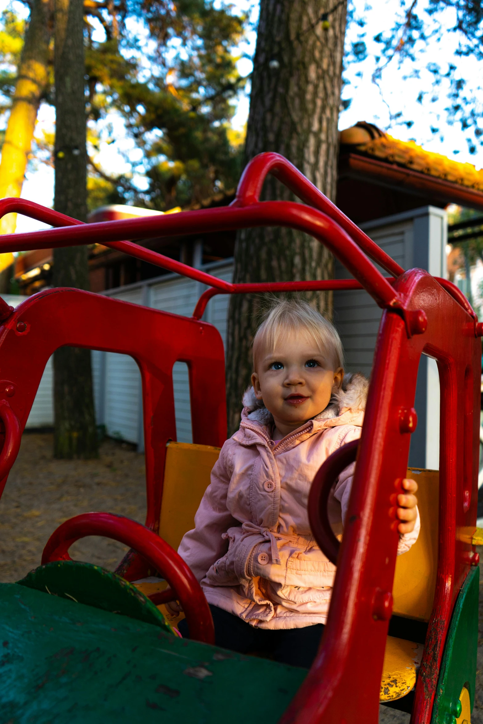 a little girl that is sitting in a toy car, a picture, by Sven Erixson, unsplash, adventure playground, square, hestiasula head, in the early morning