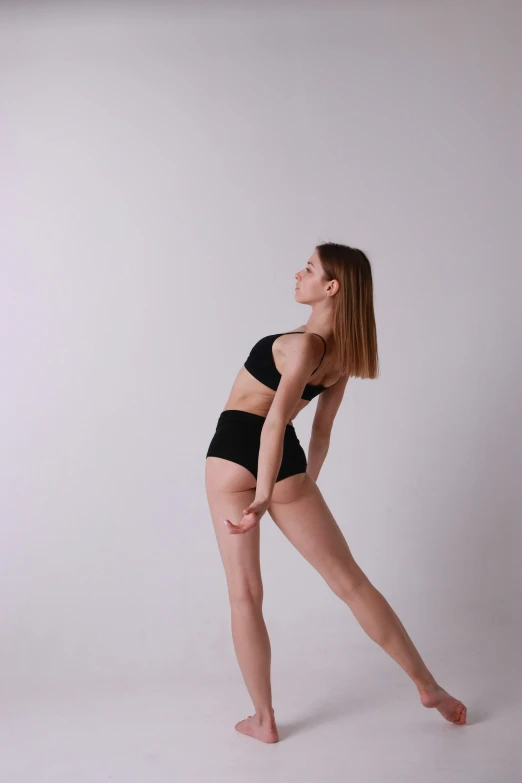 a woman in a black bikini posing for a picture, an album cover, inspired by Elizabeth Polunin, unsplash, sideview, fullbody dynamic poses, pale smooth, bra and shorts streetwear