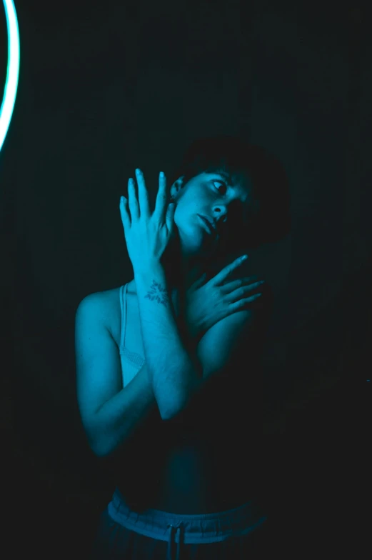 a woman standing in front of a neon clock, inspired by Elsa Bleda, pexels contest winner, blue scales covering her chest, glowing hands, infp young woman, dark dance photography aesthetic