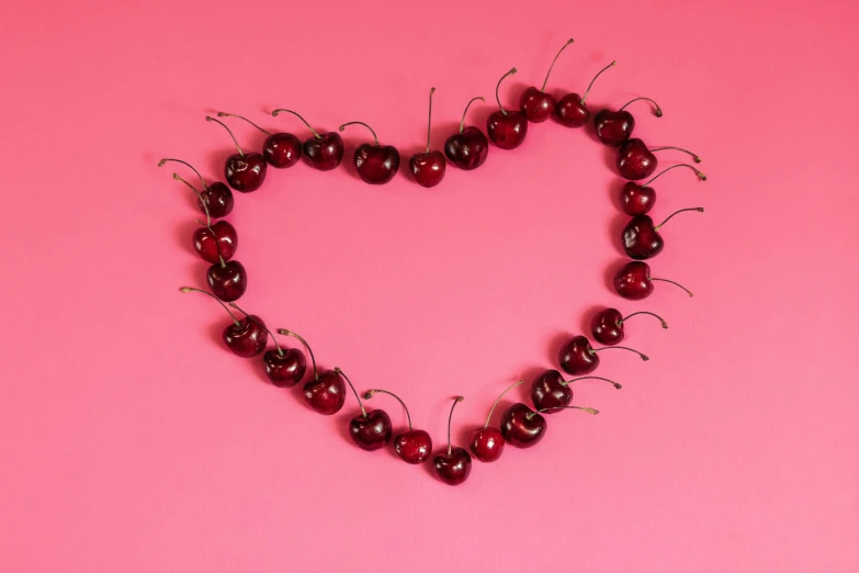 a heart made out of cherries on a pink background, by Sylvia Wishart, pexels, dark red, modeled, pochi iida, cheesy