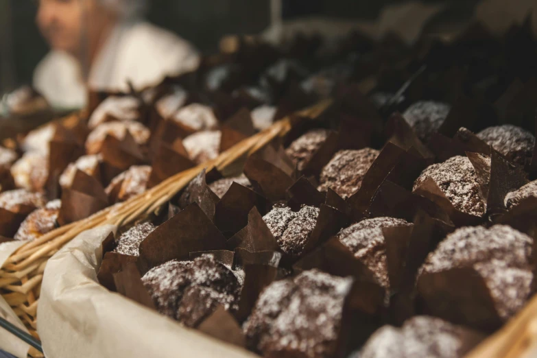 a table topped with baskets of pastries covered in powdered sugar, by Daniel Lieske, unsplash, smothered in melted chocolate, profile image, cubes on table, brunettes