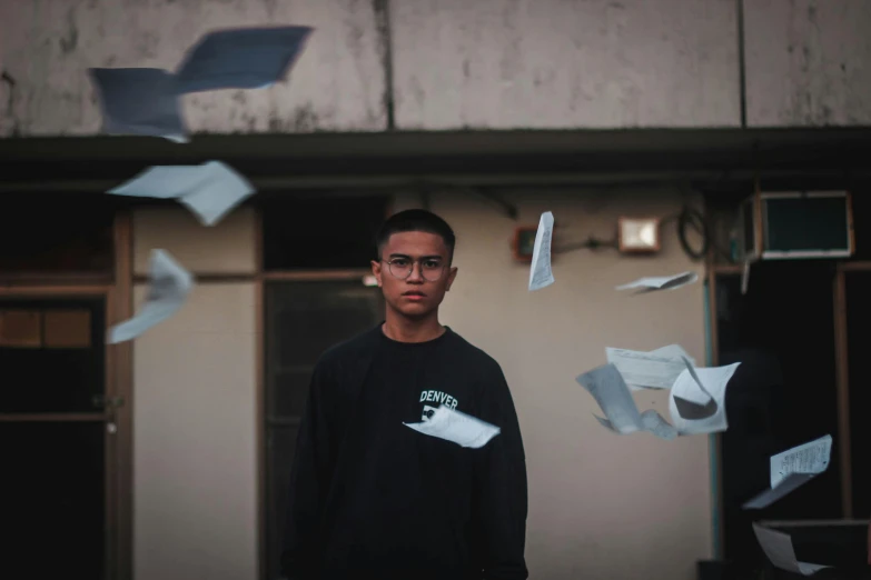 a man standing in front of a bunch of papers, pexels contest winner, male teenager, floating pieces, avatar image, cinematic full shot