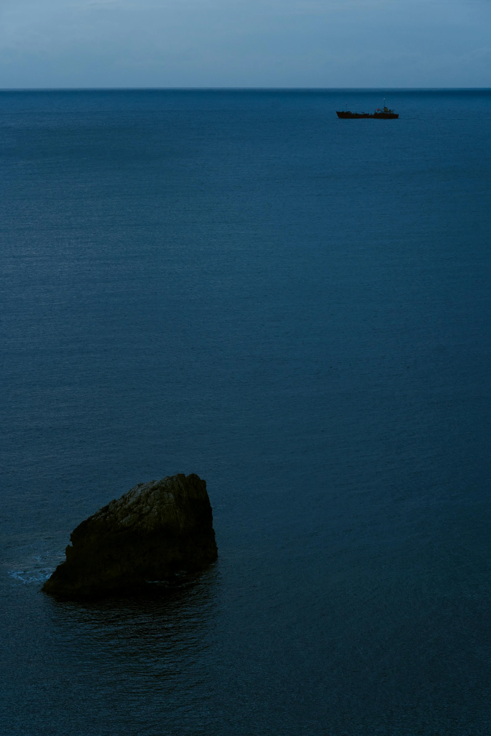 a large rock in the middle of a body of water, by Elsa Bleda, minimalism, cinq terre, medium format. soft light, late summer evening, blue: 0.5