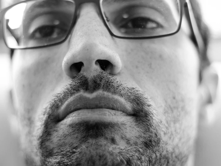 a black and white photo of a man with glasses, inspired by Chuck Close, pexels, hyperrealism, square nose, goatee, high angle closeup portrait, portrait of a young italian male