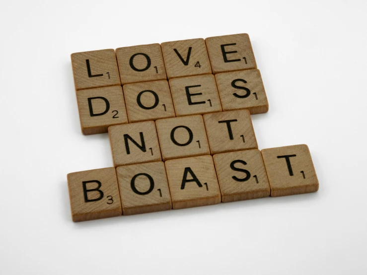 scrabbles spelling love does not roast on a white surface, by Sophia Beale, pixabay, antidisestablishmentarianism, but is mostly wood, dark souls vibe, blast