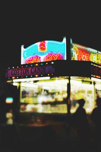 a neon sign on the side of a building, by Matt Cavotta, pexels contest winner, pop art, food stalls, made of cotton candy, carousel, grainy photograph