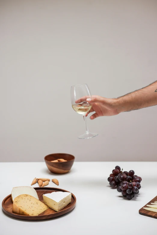 a man is pouring wine into a glass, inspired by david rubín, snacks, but minimalist, tabletop, a wide shot