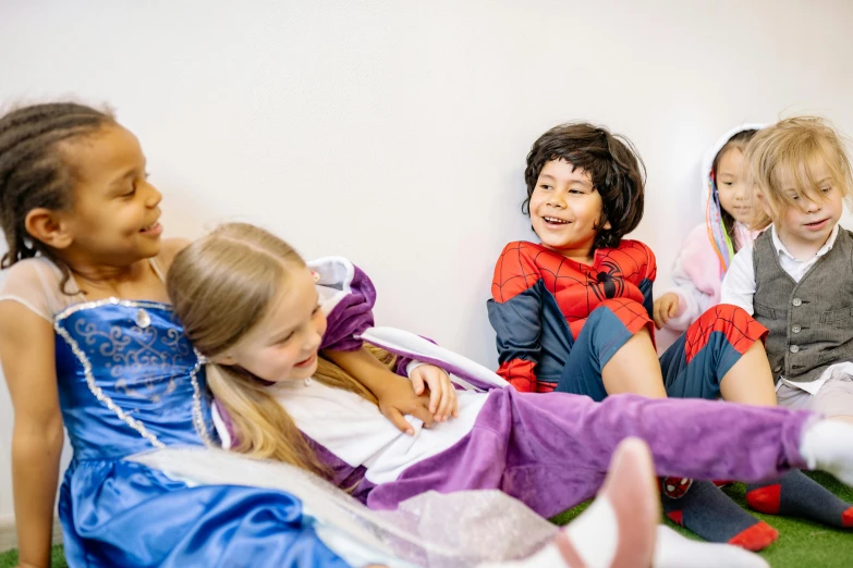 a group of children sitting next to each other on the floor, wearing hero costume, sleeping beauty fairytale, profile image, softplay