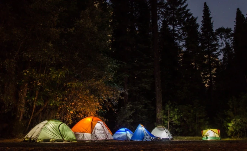 a group of tents are lit up at night, fan favorite, explore, gray, various colors