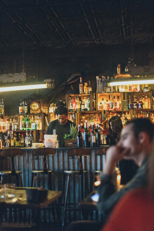 a man sitting at a bar talking on a cell phone, trending on unsplash, renaissance, wide panoramic shot, dimly lit dive bar, a quaint, a green