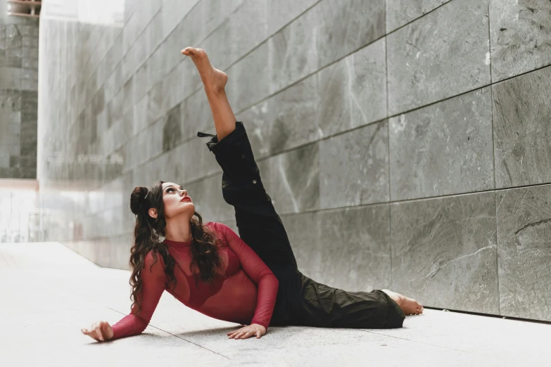 a woman doing a yoga pose in front of a wall, pexels contest winner, arabesque, doing splits and stretching, looking to the side, zenra taliyah, hispanic