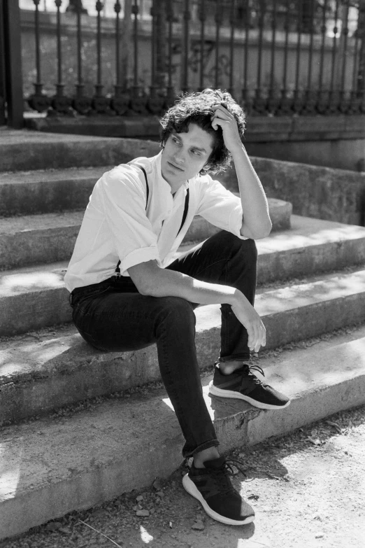 a black and white photo of a man sitting on steps, inspired by Alexis Grimou, portrait of timothee chalamet, douglas smith, clothed!! lucien levy - dhurmer, jack white