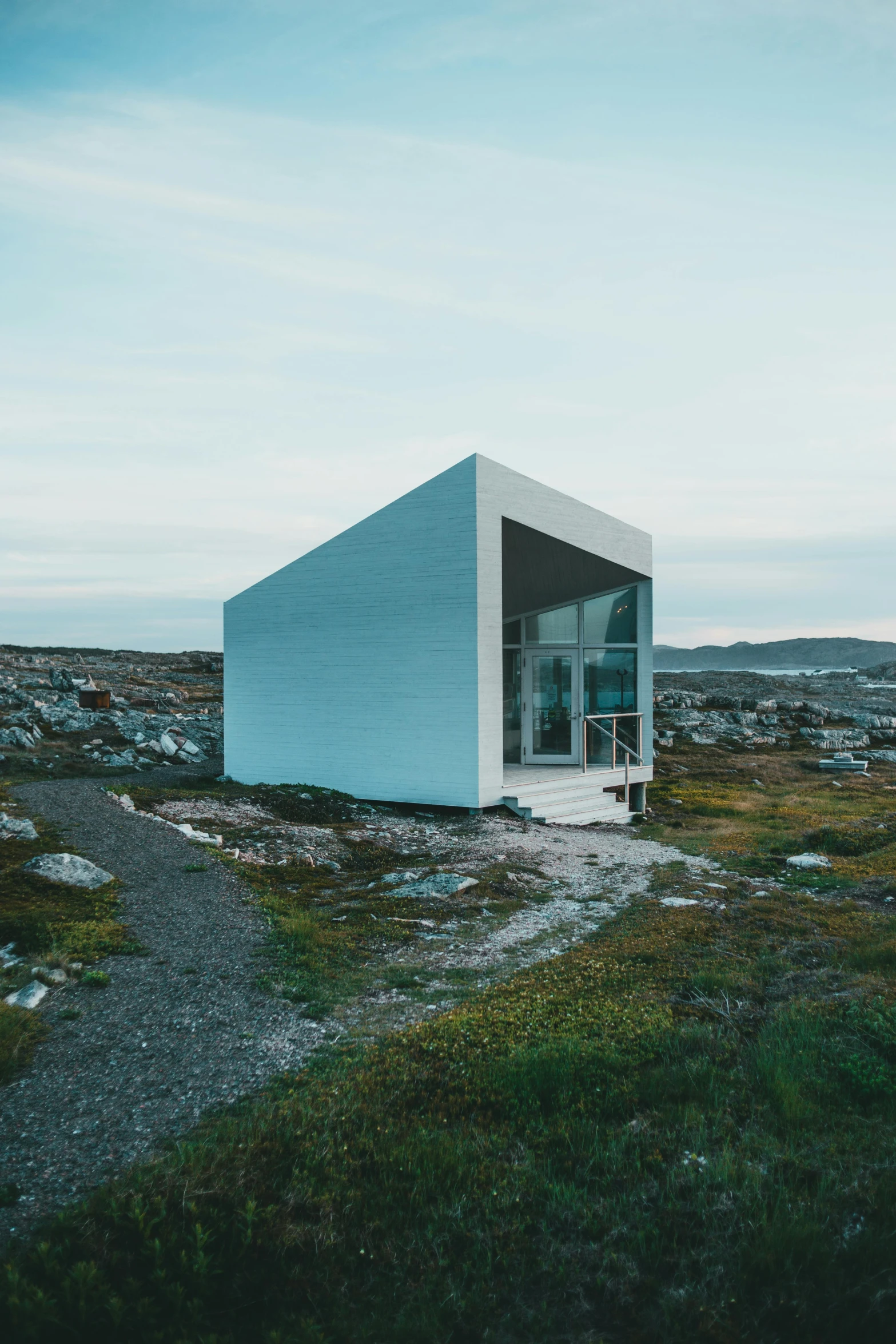 a small white building sitting on top of a hill, by Jesper Knudsen, pexels contest winner, hypermodernism, cozy environment, inuit, views to the ocean, regular build