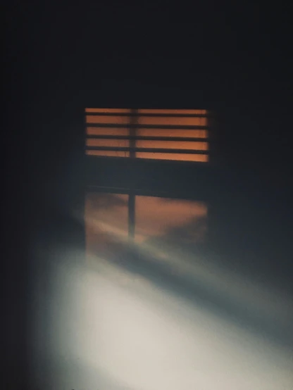 the sun shines through a window in a dark room, a picture, inspired by Elsa Bleda, smoke and orange volumetric fog, shadow filled room with gloomy, dark, bars on the windows